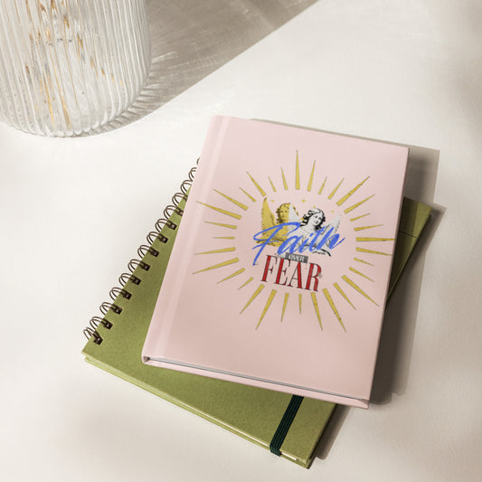 Pink notebook with 'Faith Over Fear' design on a journal